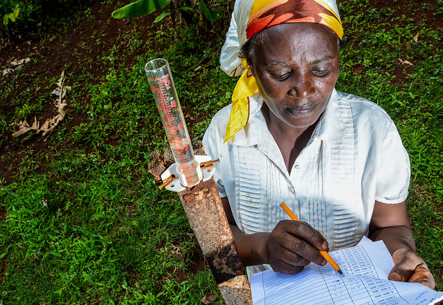 Mercy Wambui, a farmer in Kenya's Tana River Watershed, measures rainfall on her farm to track soil run-off. Credit; Georgina Smith / CIAT