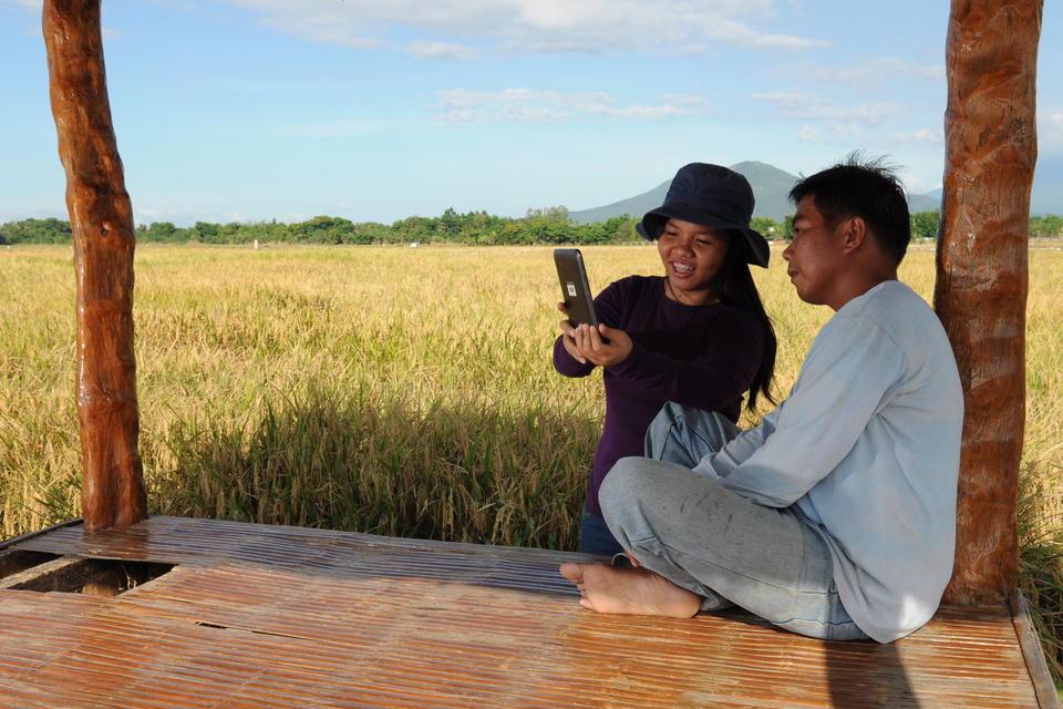 Extension officer and farmer in the Philippines using the rice crop manager